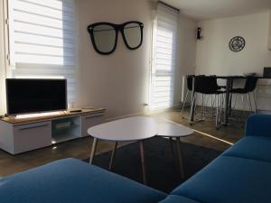 een woonkamer met een tafel en een zonnebril aan de muur bij Magnifique T3 en plein coeur de Lorient, dernier étage avec balcon terrasse in Lorient