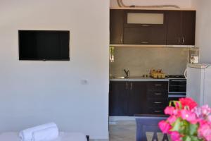 eine Küche mit braunen Schränken und rosa Blumen in einem Zimmer in der Unterkunft Vila Ervin First Floor in Ksamil