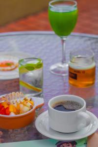 una mesa con una taza de café y una bebida en Verdegreen Hotel en João Pessoa