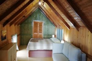 a bedroom with a bed and a couch in a room at Ocean View Cottage in Arco da Calheta