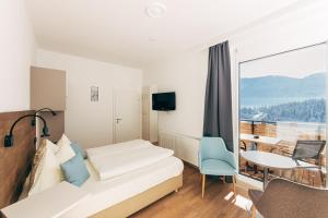 a hotel room with a bed and a table and a window at Villa Blumegg in Hermagor