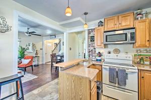 a kitchen with wooden cabinets and a stove top oven at Charming Central Lynchburg Hideout with Patio! in Lynchburg