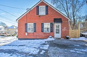 a red brick house with a white door in the snow at Charming Central Lynchburg Hideout with Patio! in Lynchburg