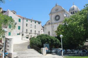 eine Gruppe von Gebäuden mit Treppen und einem Uhrturm in der Unterkunft Rooms & Studio Apartments Šibenik in Šibenik