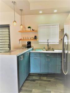 a kitchen with blue cabinets and a sink at Lovely 1 Bedroom Apartment w/private Parking in Ensenada