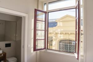 une fenêtre ouverte avec vue sur un bâtiment dans l'établissement N Apartments - Bolhão, à Porto
