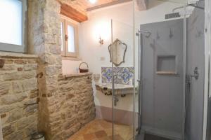 a bathroom with a glass shower and a sink at La casina del vicolo in Collelungo