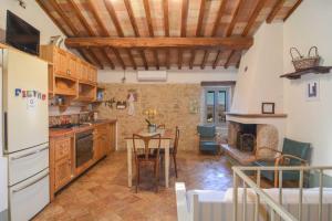 a kitchen with a refrigerator and a table in a room at La casina del vicolo in Collelungo +15 photos