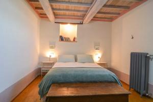 a bedroom with a bed and two tables with lamps at La casina del vicolo in Collelungo