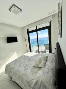 sypialnia z łóżkiem i widokiem na ocean w obiekcie Sunset Drive Resort & Spa w mieście Benidorm +37 zdjęć