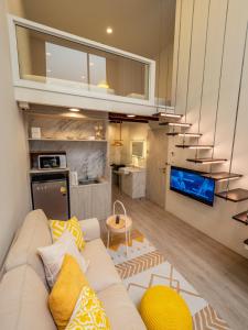 een woonkamer met een witte bank en een keuken bij Ease Me Residence in Hat Yai