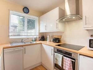 uma cozinha com um lavatório e um fogão forno superior em Taverner - Self catering holiday home close to Poole Quay em Poole