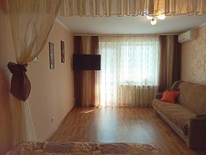 a living room with a couch and a window at Cozy apartments in the city center Kharkovskaya street in Sumy