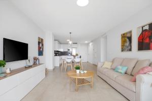 Una sala de estar con un sofá y un televisor. en Luxury Apartment Leticia, en La Cala de Mijas