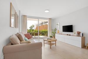 Una sala de estar con un sofá y un televisor. en Luxury Apartment Leticia, en La Cala de Mijas