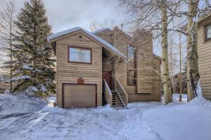 フリスコにあるMountainside 753 Homeの雪の中にガレージを設けた木造家屋