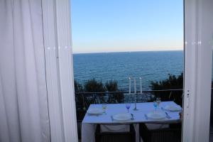 a table with a view of the ocean from a balcony at Conca Verde c21- BEACH FRONT little villa- POOL, private JACUZZI sea view in Marina di Andora