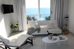 a living room with a white couch and chairs at Conca Verde c21- BEACH FRONT little villa- POOL, private JACUZZI sea view in Marina dʼAndora