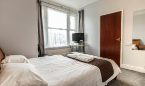 a bedroom with a large bed and a window at Shelford Lodge in Cambridge