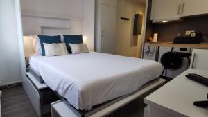 um quarto com uma grande cama branca com almofadas azuis em Portes de la vieille ville em Annecy