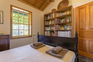 a bedroom with a bed with a book shelf with books at Tapadinho Nature and Pool - Countryside Villa in Raiva +54 photos