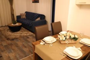 Green Gold في Čaglin: طاولة غرفة الطعام مع الأطباق والزهور عليها