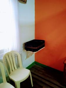 um quarto com duas cadeiras e uma mala numa prateleira em Casa LuNa -Estratégica Ubicación- em Medellín