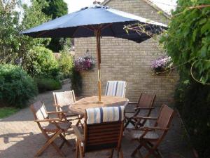 einen Tisch und Stühle mit Sonnenschirm auf einer Terrasse in der Unterkunft Leverton House in Cambridge