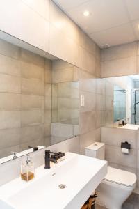 a bathroom with a sink and a toilet and a mirror at Apartamentos Principe 7 in Madrid