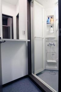 frigorifero bianco con porta in vetro in camera di BEE-HIVE巣鴨(Sugamo)【男性専用・Male Only】 a Tokyo