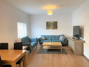 a living room with a blue couch and a table at Luxury 2 bed Apartment-Golden Triangle w/ Parking in Norwich