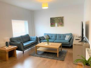 sala de estar con sofá azul y mesa en Luxury 2 bed Apartment-Golden Triangle w/ Parking, en Norwich