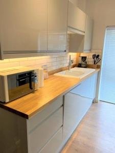 a kitchen counter with a microwave and a sink at Luxury 2 bed Apartment-Golden Triangle w/ Parking in Norwich