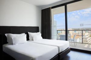 Cama ou camas em um quarto em RR Hotel da Rocha