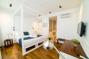 a bedroom with a bed and a desk and a tv at Grand Hotel Urban in Antananarivo