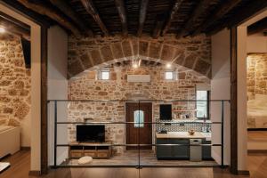 Duży pokój z ceglaną ścianą i kominkiem w obiekcie La casa dell'arch w mieście Charaki