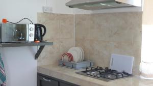 a kitchen with a stove top and a microwave at CHEZ JOHNNY in Grand Baie