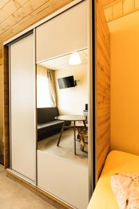 Pokój z przesuwnymi szklanymi drzwiami prowadzącymi do sypialni w obiekcie L&B Szczyrk Centrum w Szczyrku