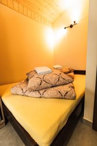 a bed in a room with a yellow wall at L&B Szczyrk Centrum in Szczyrk