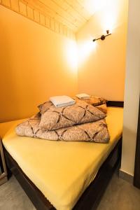 a bed in a room with a yellow wall at L&B Szczyrk Centrum in Szczyrk