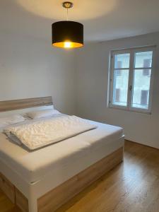 Schlafzimmer mit einem Bett mit einer Lampe und einem Fenster in der Unterkunft Ferienhaus Ritter in Hard