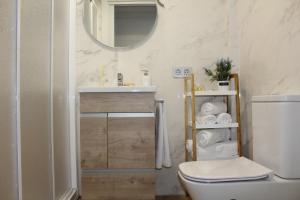a bathroom with a toilet and a sink and a mirror at Apartamento Catedral in Almería +33 photos