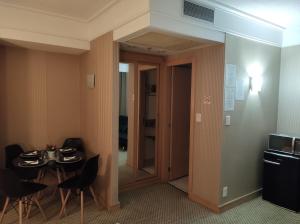 um quarto com uma mesa e uma porta que leva a uma cozinha em Flat Guarulhos em Guarulhos