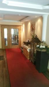 a living room with a red carpet and a bed at Hotel Alpenblick in Pfelders