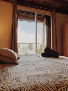 - une chambre avec un grand lit et une grande fenêtre dans l'établissement Gîte Carmelie, à Sainte-Luce