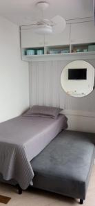 a bedroom with a bed and a tv on the wall at Santos Unlimited 2 Dormitórios, 32o andar com vista Mar! in Santos +37 photos