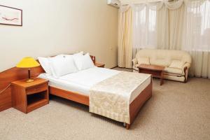 Habitación de hotel con cama y silla en Hotel Aliance, en Orsk