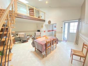 um quarto com uma mesa e cadeiras e uma escada em Cottage de charme classé 3 Etoiles - 8 min CNPE Civaux em Gouex