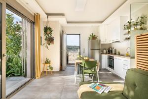 a kitchen and living room with a table and chairs at Olive Lemon Biophilic House & Lush Forest Garden in Vamos