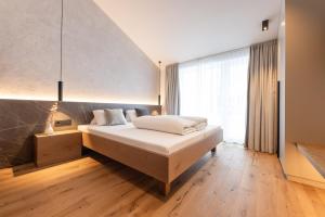 ein Schlafzimmer mit einem Bett und einem großen Fenster in der Unterkunft Max Mountain Apartments in Neustift im Stubaital